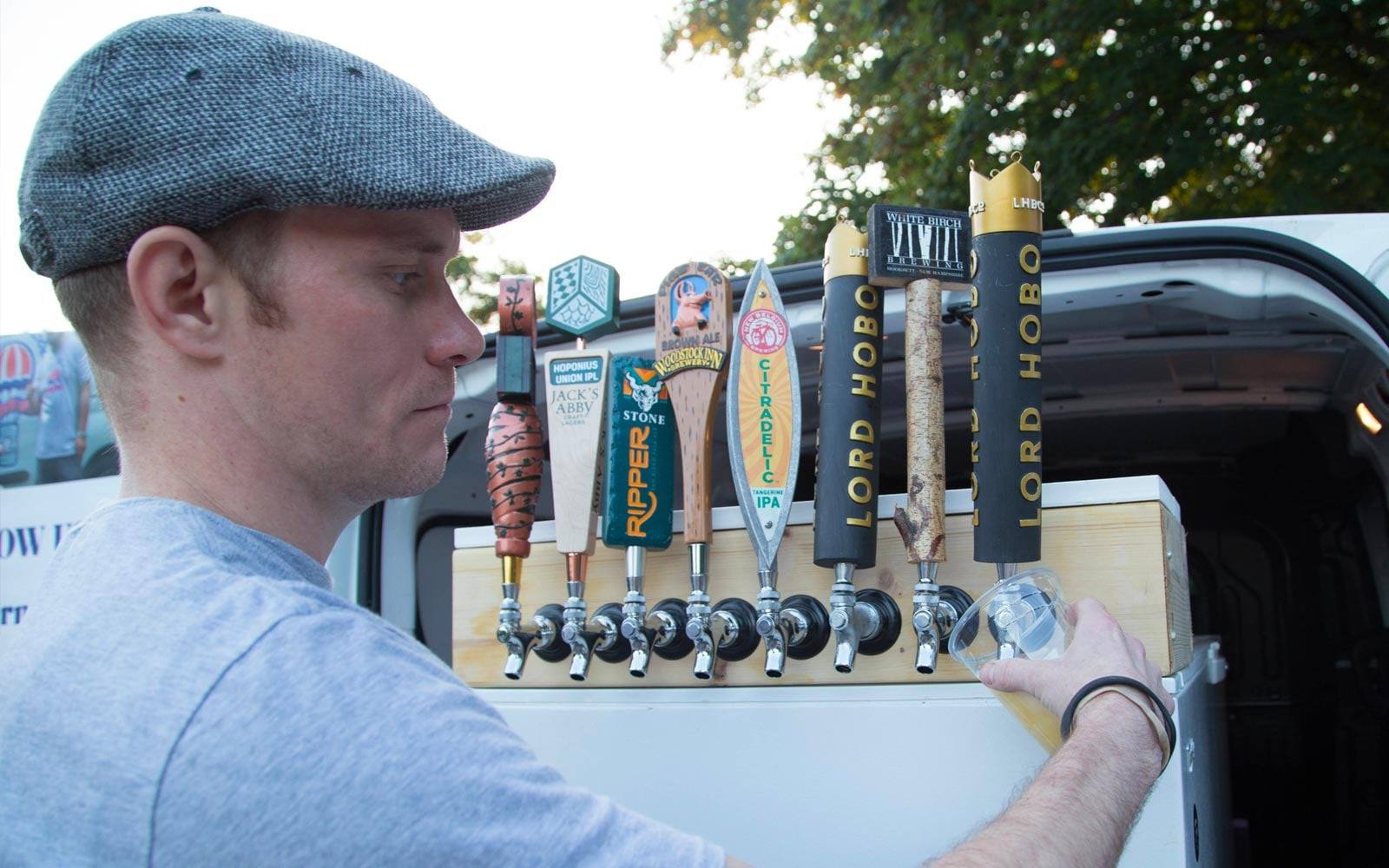 A bartender pouring from the draft taps on The Beer Mobile truck