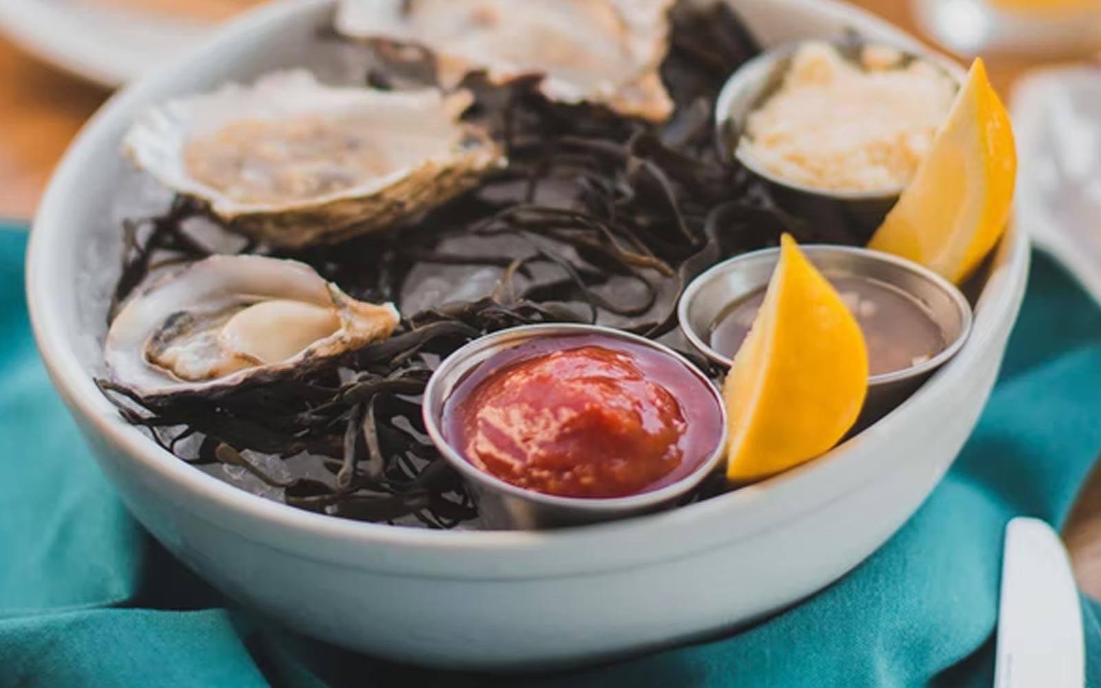 Fresh oysters on ice with cocktail sauce and lemon